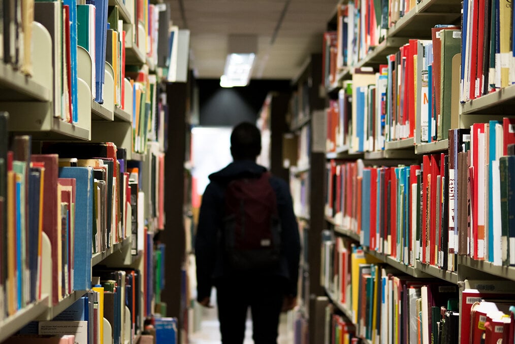 A student in the middle of a library